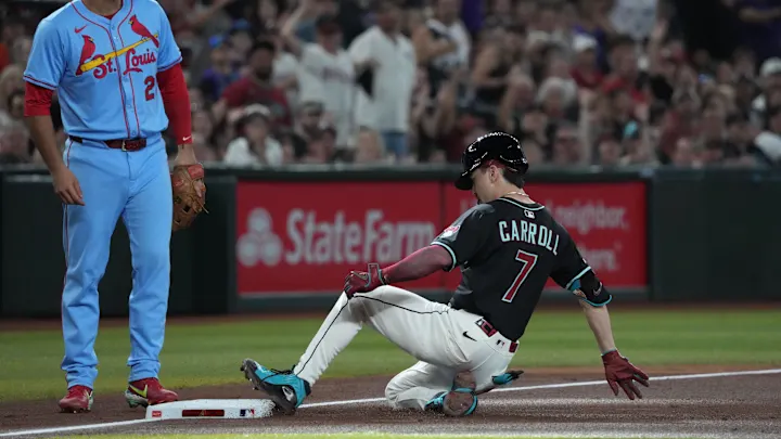 Corbin Carroll sliding into second base with fans cheering in the background.