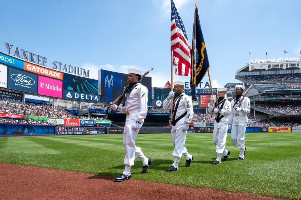 Fans waving team flags at Fenway, Yankee Stadium and Rogers Centre.