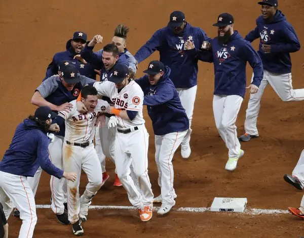 Collins is mobbed by teammates at home plate.