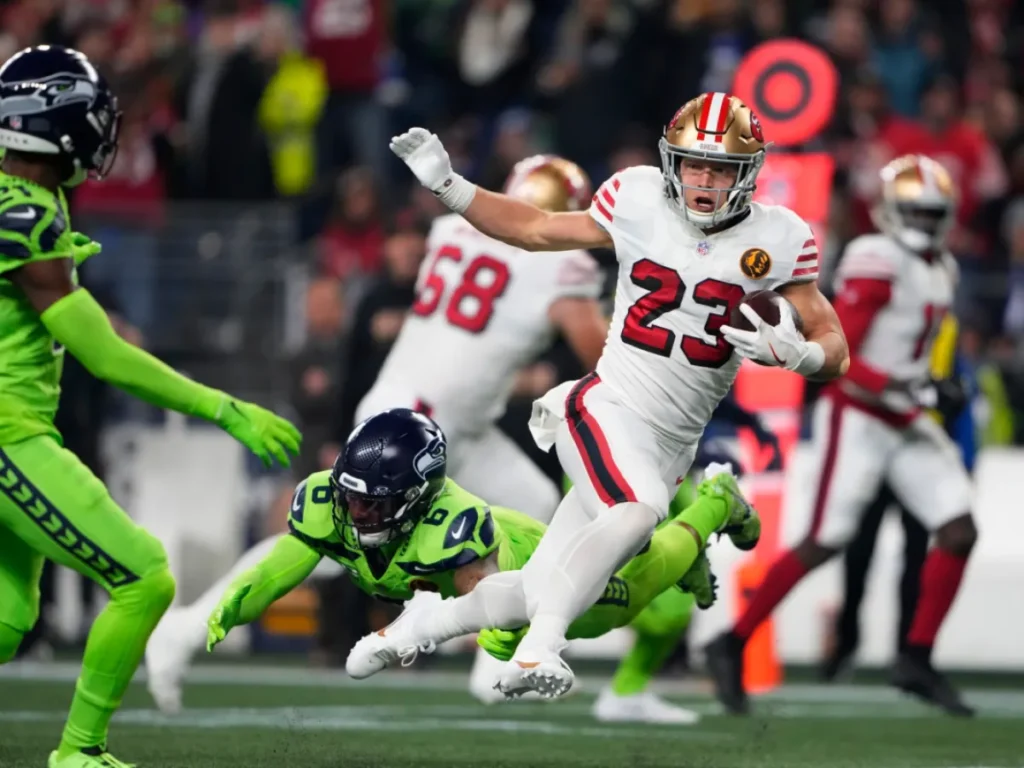 McCaffrey breaking up a run with Seahawks defenders chasing him.