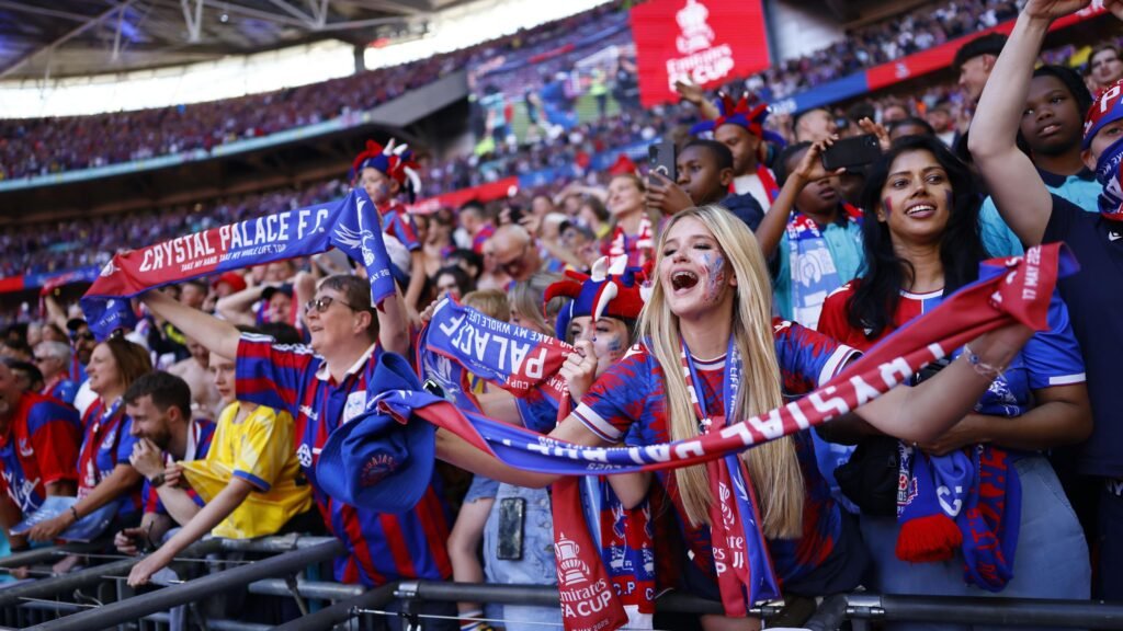 📸 Image suggestion: Fierce Crystal Palace players waving flags against Fredrikstad supporters with red-and-white banners.