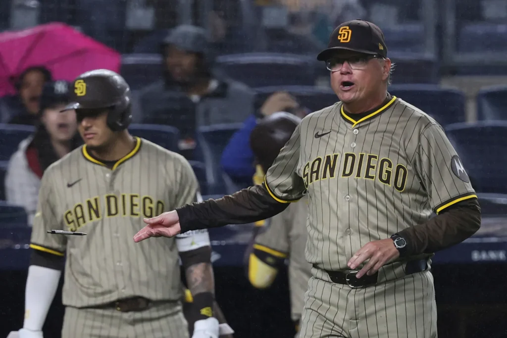 Padres manager in the dugout after the game, proudly pointing to his players.