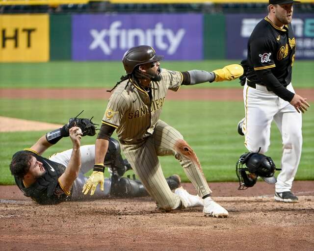 Tatis Jr. sliding into second base, mud flying as he steals.