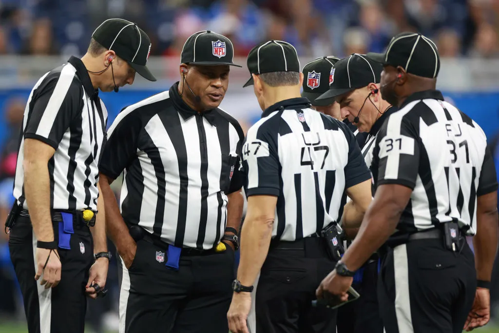 A photo of an NFL referee holding a football during pre-game announcements.