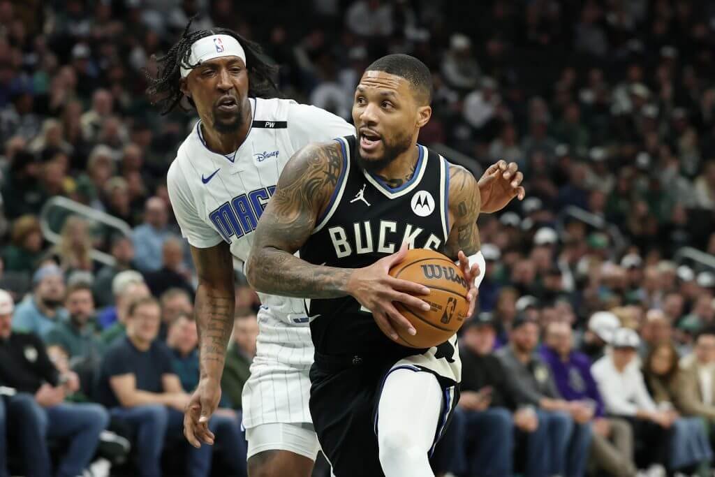 Lillard is driving towards the basket and Giannis is cutting towards the hoop.