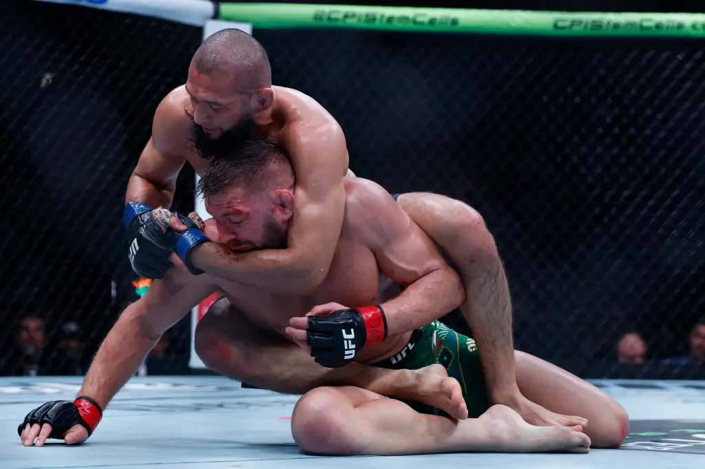 Action shot of Chimaev landing heavy ground strikes on du Plessis