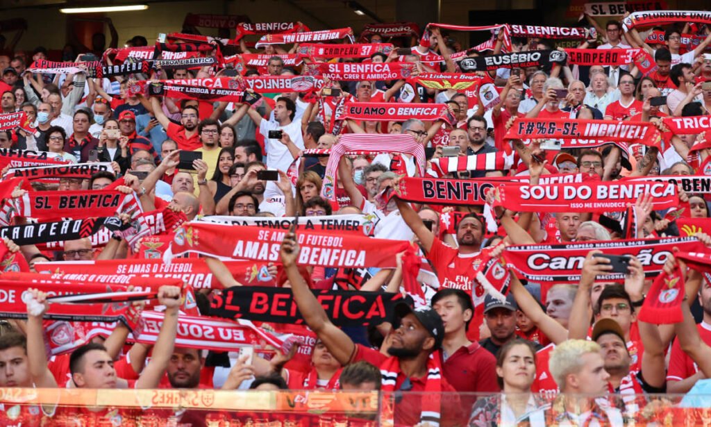 Fredrikstad fans holding red and white scarves at their home stadium.