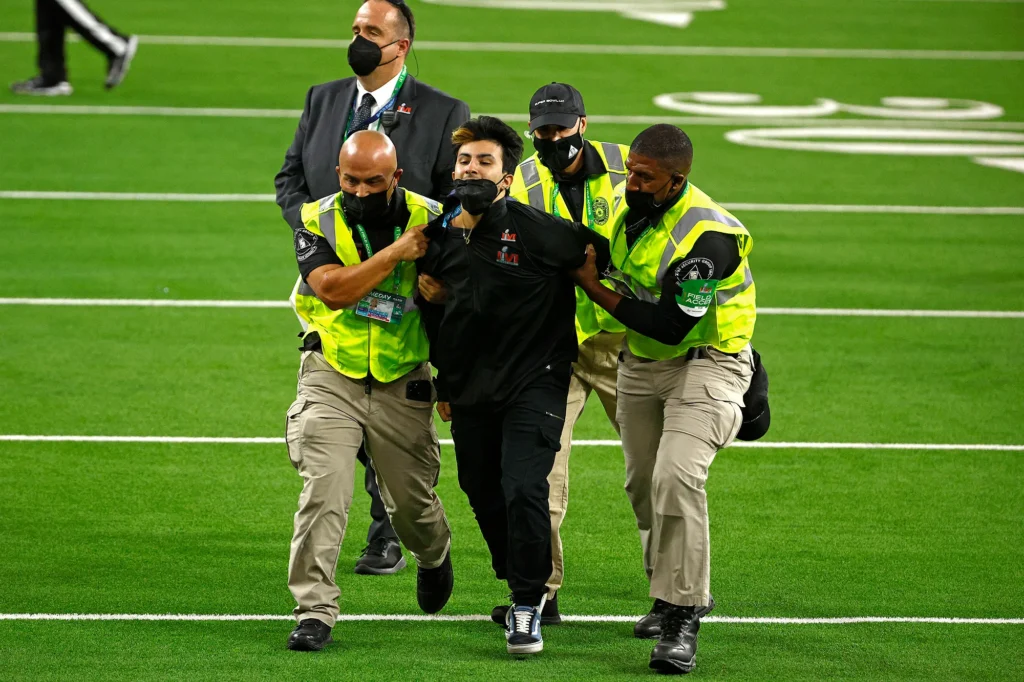NFL security guards tackle a fan who ran onto the field.