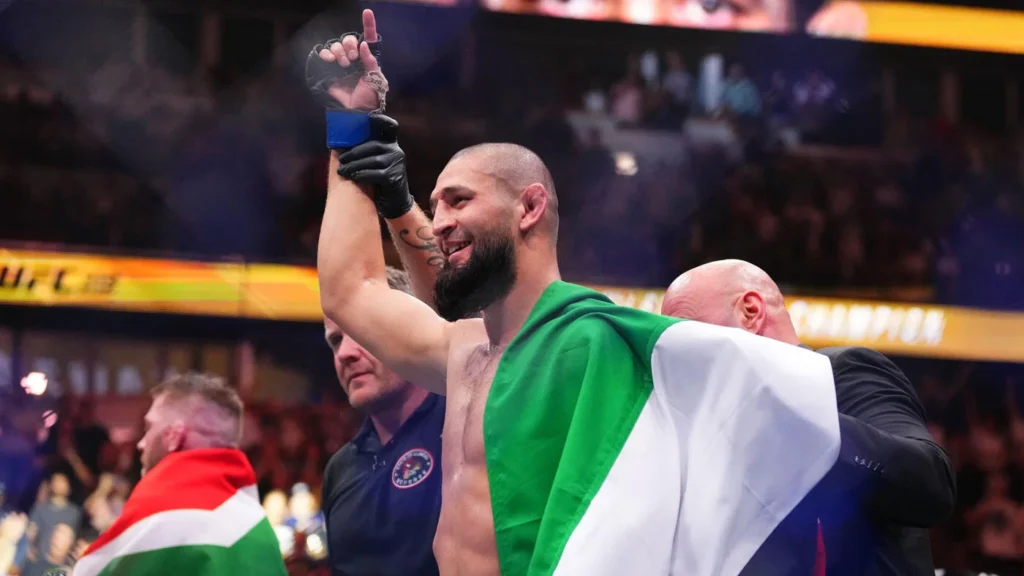 Chimaev holding the Middleweight belt high above his head in celebration